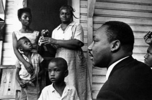 3-Dr. Martin Luther King Jr., right, chats with Greenwood, Mississippi African Americans on their front porch