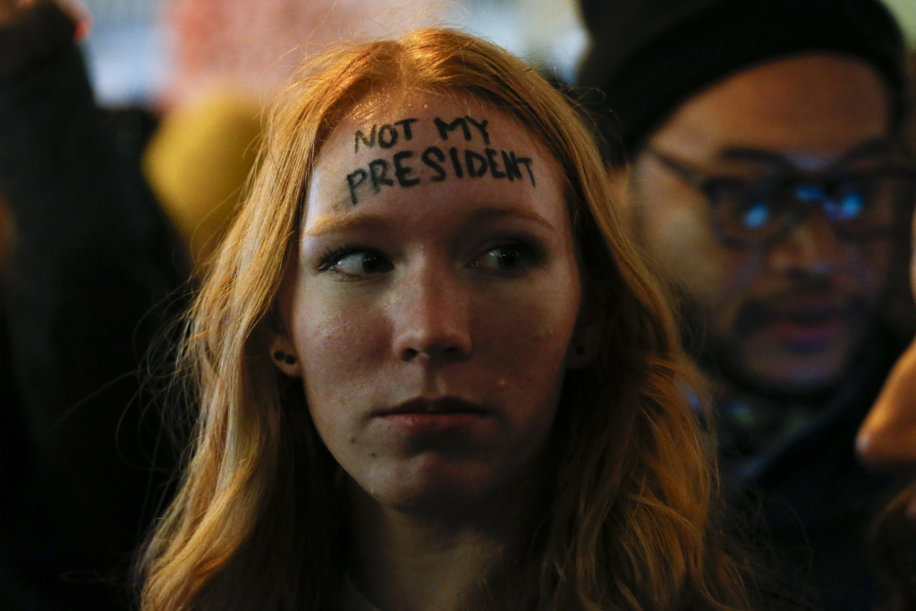A woman looks on as she takes part in a protest against President-elect Donald Trump in front of Trump Tower in New York on November 10, 2016. / AFP / KENA BETANCUR (Photo credit should read KENA BETANCUR/AFP/Getty Images)